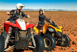 Fototapeta Sawanna - Quad driving people - happy smiling couple bikers in sand desert. Namib, Namibia.