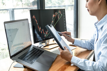 Aufkleber - Businesswoman investor having planning and analyzing graph data with display screen the data presented and deal on a stock exchange
