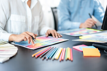 Poster - Two creative graphic designer team working on color selection and drawing on graphic tablet, Color swatch samples chart for selection coloring in inspiration to creativity at workplace