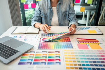 Poster - Young creative graphic designer working on color selection and drawing on graphics tablet at workplace, Color swatch samples chart for selection coloring in inspiration to create new collection