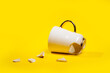 Broken tea cup isolated on yellow background. Cracked coffee mug and fragile ceramic pieces