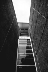 Architectural vertical composition of walls, windows, back of buildings and clean sky in a alley (in black and white)