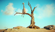 Giraffe stands on thin branch of withered tree in surreal landscape