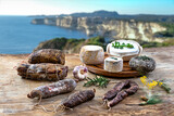 Fototapeta Dmuchawce - Local wild pork delicatessen, and corsican cheese, sea landscape background