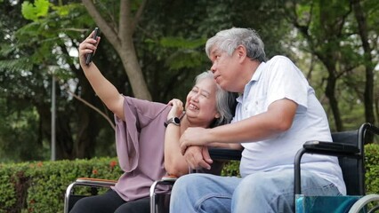 Wall Mural - Elderly men and women sitting in wheelchairs in the park. holding smartphones taking pictures together Talk to each other, smile, be happy. Elderly couple. Health care in retirement. senior society