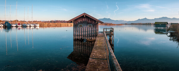 Papier Peint - Scenic nature landscape. Sunrise on Chiemsee lake with vivid sky. Beautiful alpine sunset view on mountain lake and fishing hut near Rimsting at famous Chiemsee, Bavaria, Germany. nature background