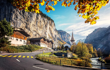 Fototapete - Picturesque autumn landscape. Panoramic view of stunning mountain scenery in the Alps with fresh green meadows with fog in mountains on a  sunny morning in autumn. Lauterbrunnen, Switzerland.