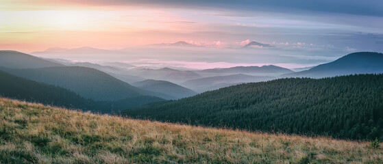 Fototapete - Impressively beautiful Fairy-tale mountain landscape in Alps. Panoramic view of beautiful mountain scenery. Amazing nature background. Rolling hills with morning fog under sunlight.