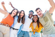 © carlesiturbe - Low angle view of a happy group of multiracial friends having fun and looking at camera , enjoying outdoors. Multiethnic cheerful young people