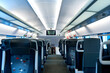 The deserted interior of a high-speed train. Rows of empty seats