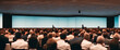 © Nedrofly - Business and Entrepreneurship Symposium. Speaker giving a talk at a business meeting. Audience in the conference room.Conference taking place in a large conference room