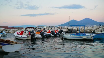 Wall Mural - Naples, Italy - 12.06.2022: Fishing boats and Vesuvius mountain.