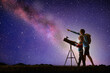 © famveldman - Man and child looking at stars through telescope