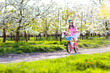 © famveldman - Kids on bike in spring park. Girl riding bicycle.