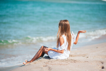 Sticker - Little adorable girl playing on beach with sand