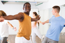 Woman And Man Practicing Social Dance Moves In Pair During Group Class