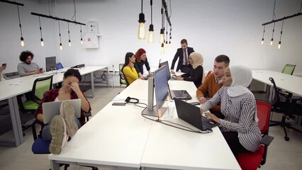 Startup business and entrepreneurship problem solving. Young AI programmers and IT software developers team brainstorming and programming on desktop computer in startup company share office