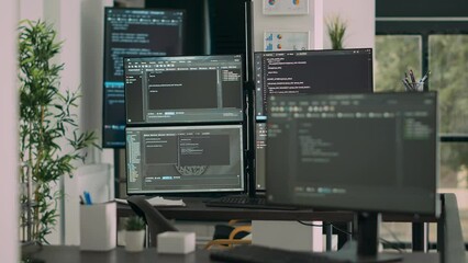 Computer screens on desk in empty data room displaying program code and algorithms, developing new user interface. Agency network servers with cloud computing script in software it office.