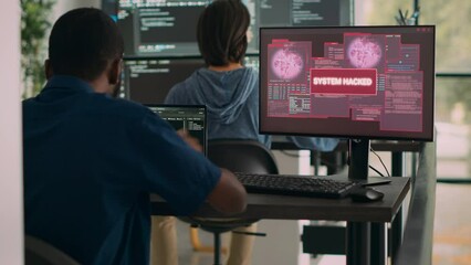 African american it engineer writing code encountering hacking alert on computer, dealing with unexpected system error and message flashing on screen. Cyber security development office.