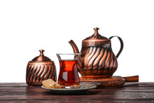 Cup Of Turkish Tea, Sugar Bowl And Teapot On Wooden Table Against White Background