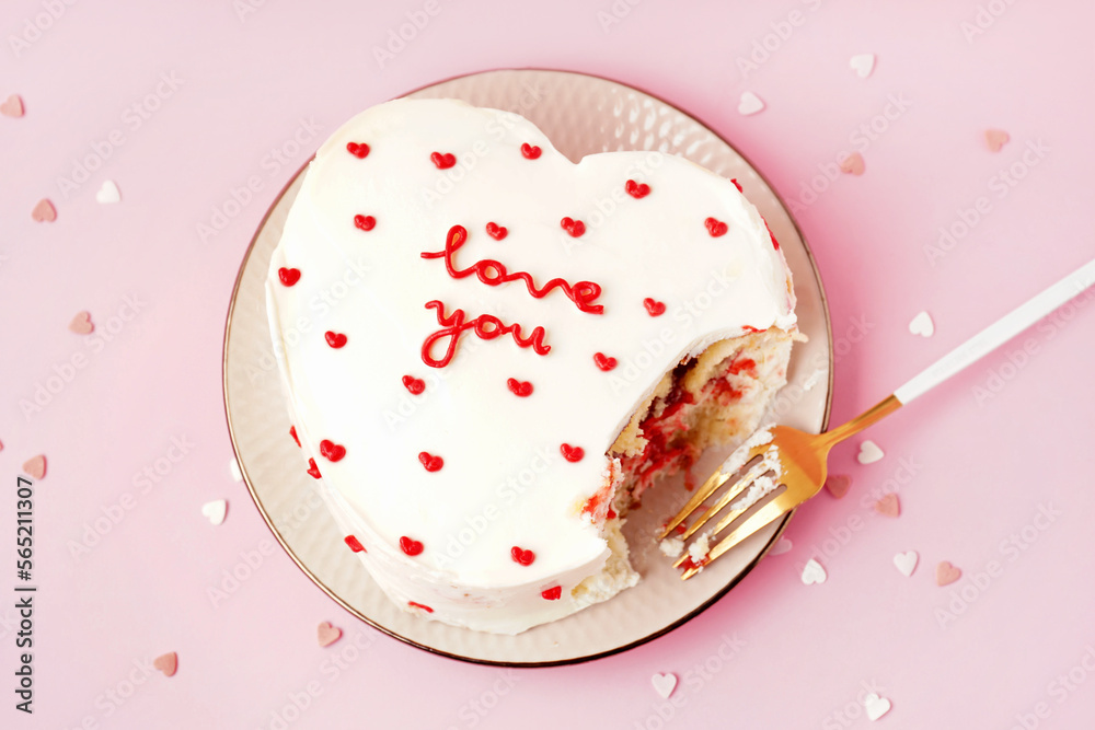 Plate with heart-shaped bento cake on pink background. Valentine's Day celebration