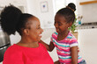 © Wavebreak Media - Happy african american grandmother and granddaughter embracing in kitchen