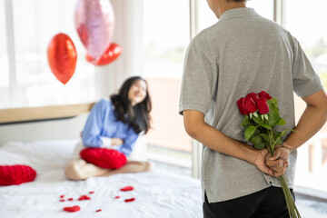 loving couple  Man with rose and gift on back in bedroom valentines day concept.