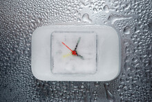 Overhead View Of Frozen Clock On Wet Table