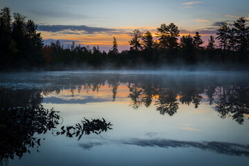 Wall Mural - The colors of an autumn sunrise creep into the sky over a secluded Northwoods lake.