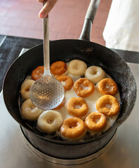 Poster - Donuts are fried in a frying pan in oil.