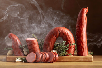 Wall Mural - Smoked sausage with thyme and garlic on a wooden table.