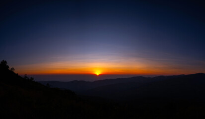 Wall Mural - panorama aerial view big sun , sunrise over dark mountain with fog over the ground.the early evening