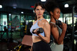 © offsuperphoto - young athletic women smiling and lifting dumbbell in the gym