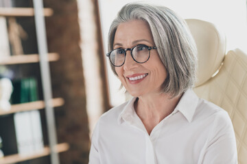 Sticker - Photo of positive cheerful aged lady company founder sit leather chair toothy smile spacious bright office indoors