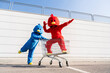 © VISTA by Westend61 - Woman wearing red duck costume having fun with man pushing shopping cart