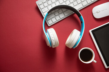 Wall Mural - White wireless headphones, coffee and other objects on the bordeaux background.