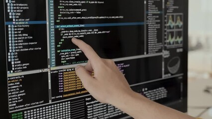 Unrecognizable software developer reading program code on black screen of computer monitor