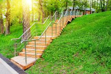 New Wooden Staircase With Metal Handrails In Public Park. Steep Staircase With Wooden Steps Going Up