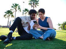 Woman And Man Talking While On A Phone In A Park
