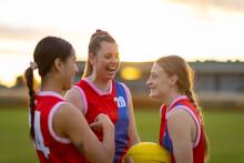 Three Female  Football Players Talking  And Laughing On The Field