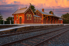 Dramatic Orange Storm Clouds Over An Historic Rural Railway Station At Sunrise