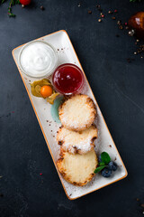 Poster - Fried cheese pancakes with jam, sour cream and blueberries on a plate.