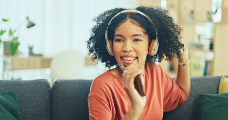 Wall Mural - Black woman, dancing and headphones on sofa, being content and singing words in living room. Young girl, headset and digital device for contemporary dancer, moving with rhythm and relax on break.