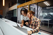 © ADDICTIVE STOCK - Cheerful colleagues working on project using gadgets