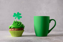 St. Patrick's Day Food. Irish Coffee In Green Cup And Chocolate Cupcake Decorated Whipped Green Cream On Gray Background. Close Up.