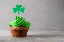 St. Patrick's Day Tasty Homemade Cupcake With Green Whipped Cream Decorated Clover On Gray Background. Copy Space. Close Up.