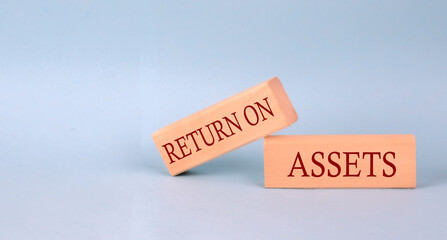 Poster - RETURN ON ASSETS text on the wooden block, blue background