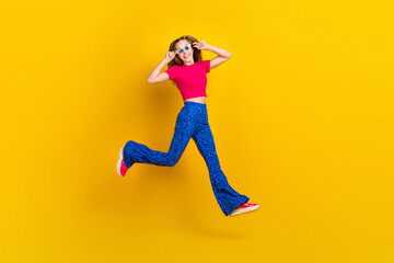 Wall Mural - Photo of cheerful cute lovely lady wear trendy outfit running empty space party weekend summer holiday isolated on yellow color background