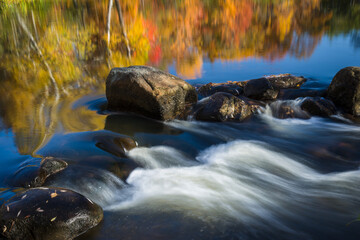 Wall Mural - Reflections of fall colors above a riffle in a Northwoods river.  Vilas County, WI