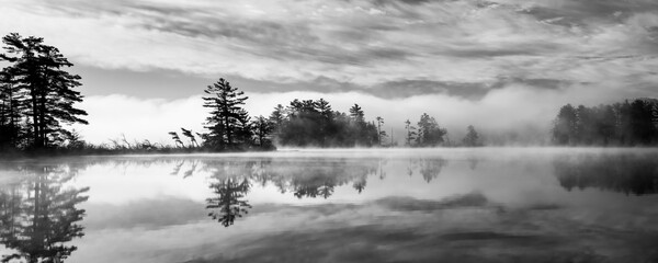 Wall Mural - Mist and fog and clouds mix together to create a surreal sunrise scene on a Northwoods lake.  Oneida County, WI.
